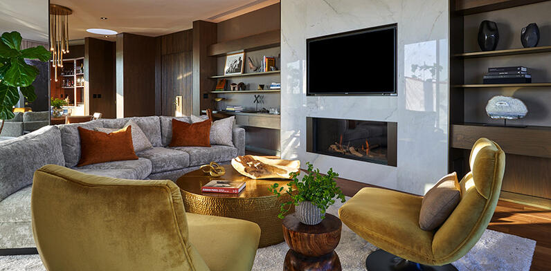 Living room with sofa and armchairs in front of fire and TV
