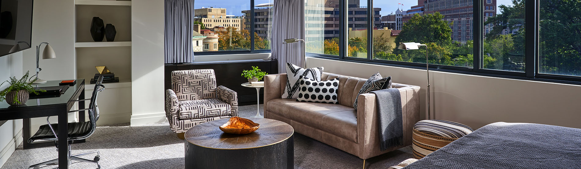 Suite living room with large windows and view of city