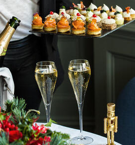 Two glasses of champagne and a tray of canapés