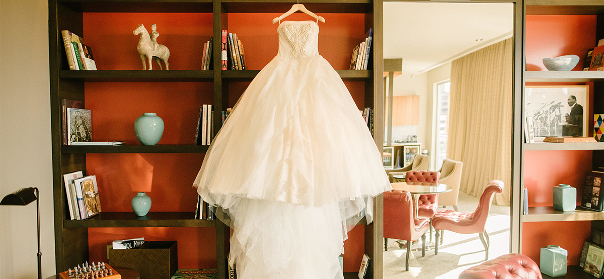 Wedding dress hanging up beside shelves