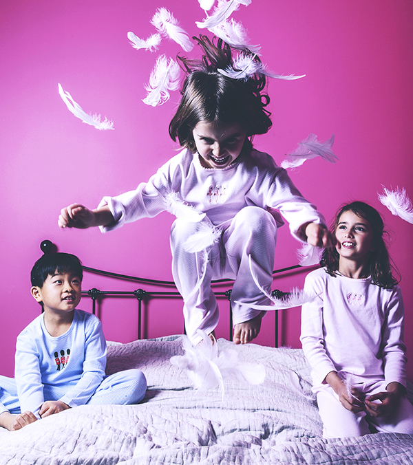 Children jumping on a bed