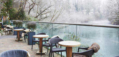 A wintry scene at the River Lee Hotel: a terrace overlooking the foggy river and leafless trees.